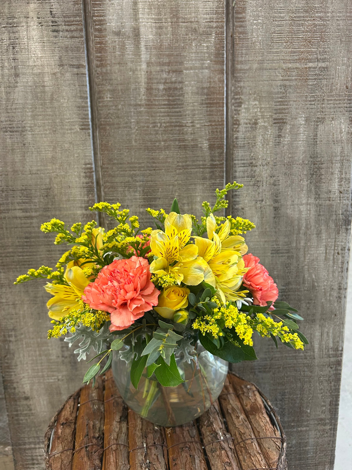 Yellow flowers with pops of coral make for the perfect arrangement sure to brighten any day.