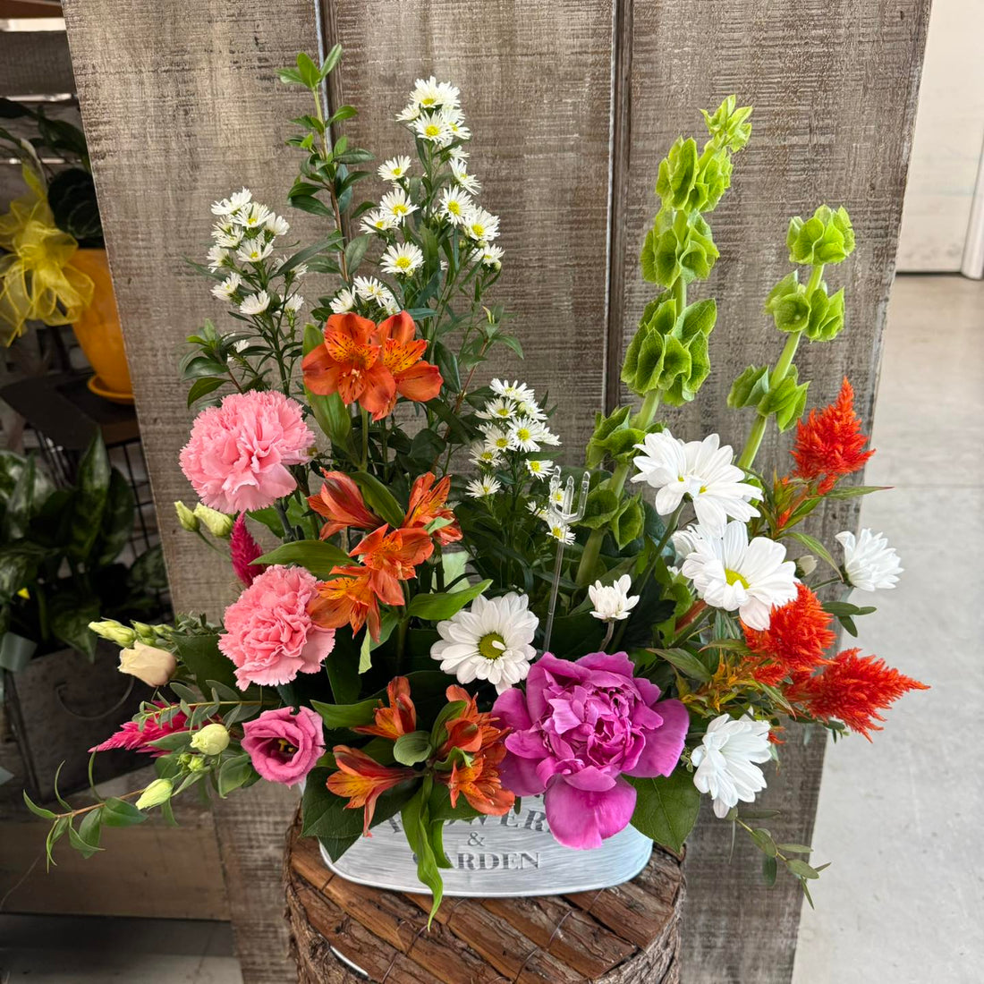 Colorful flower arrangement in a wooden basket with a neutral background
