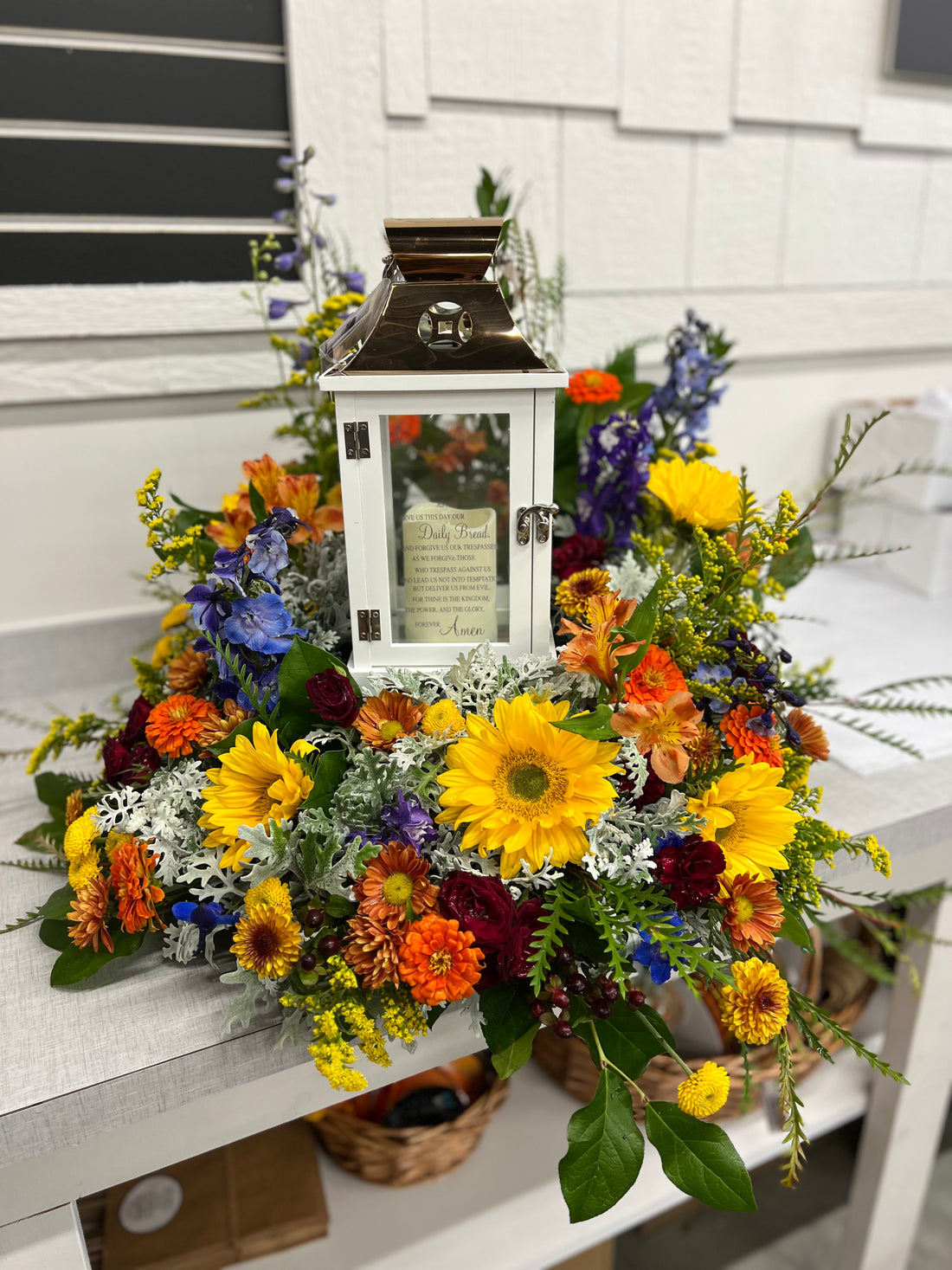 Elegant sympathy floral arrangement designed around a cremation urn with fresh flowers and greenery.